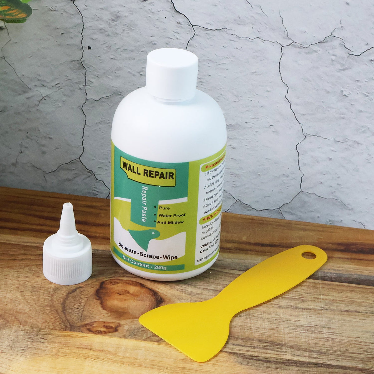 Hand applying wall filler cream to a damaged wall surface.
